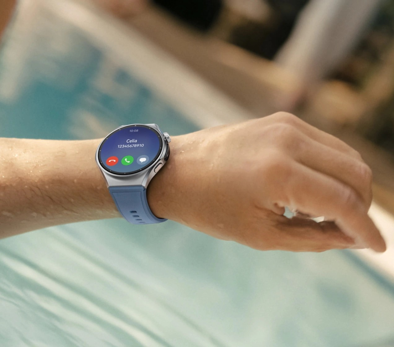 Smartwatch na nadgarstku wyświetla połączenie od Celii w pobliżu basenu.