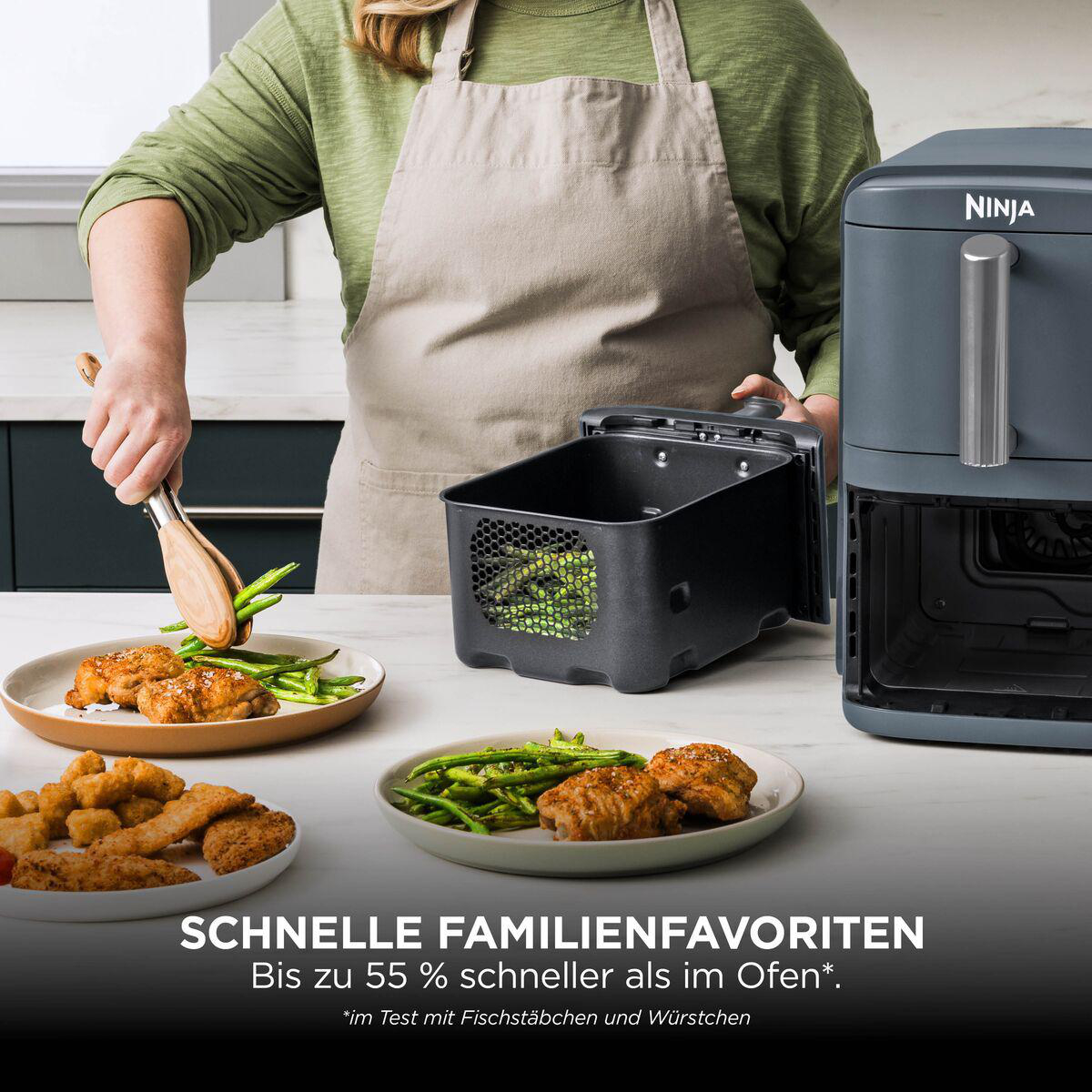 Person mit Schürze serviert grüne Bohnen und Hähnchen von einem Ninja-Heißluftfritteusenkorb auf Teller.
