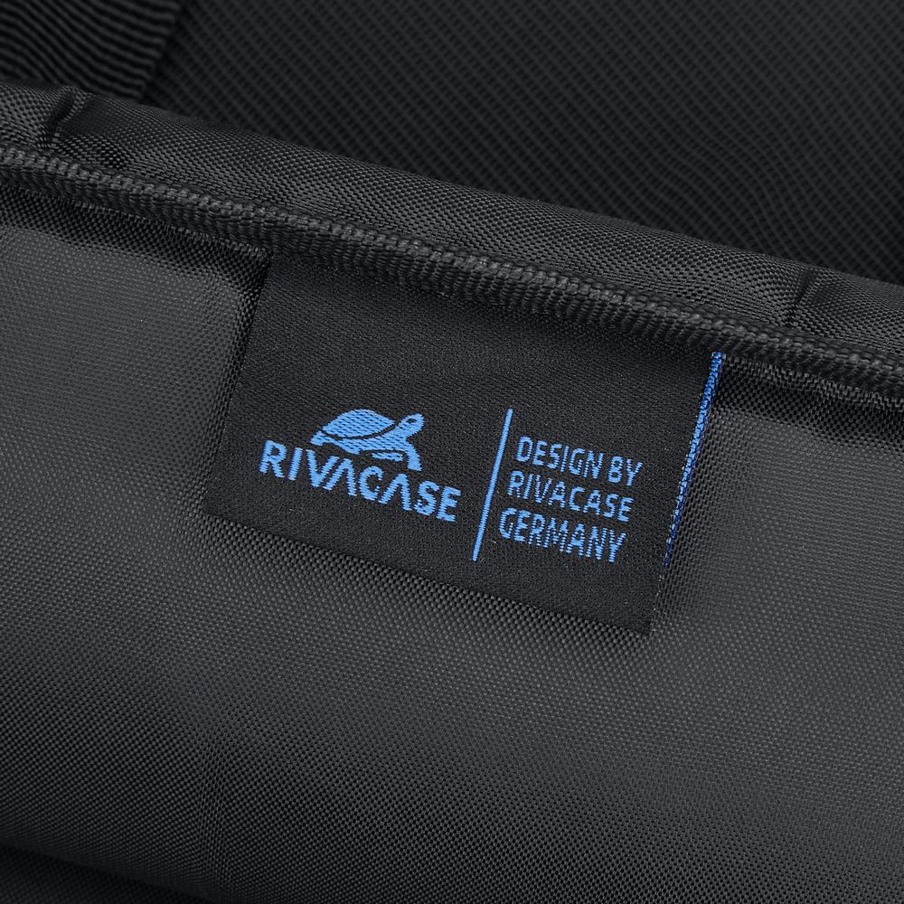Fekete textilcímke kék Rivacase logóval és a "Design by Rivacase Germany" felirattal egy táskán.