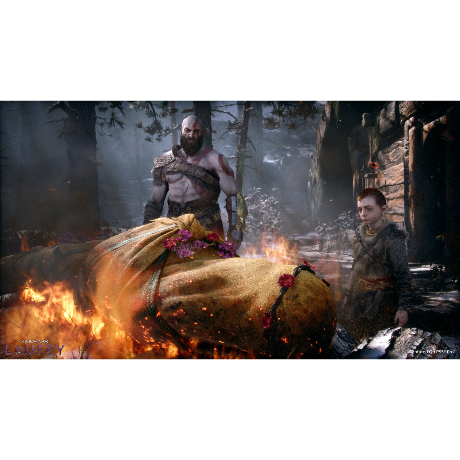 Kratos en Atreus in een bos bij een brandende brandstapel.