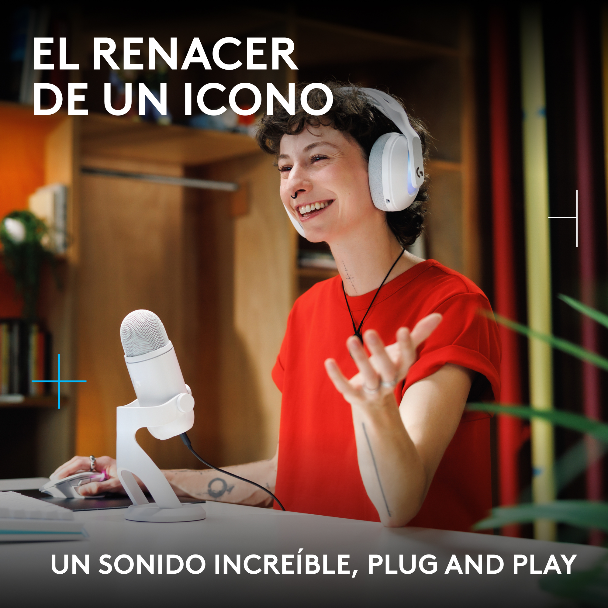 Una persona sonriente con camisa roja usa auriculares blancos y habla por un micrófono blanco.