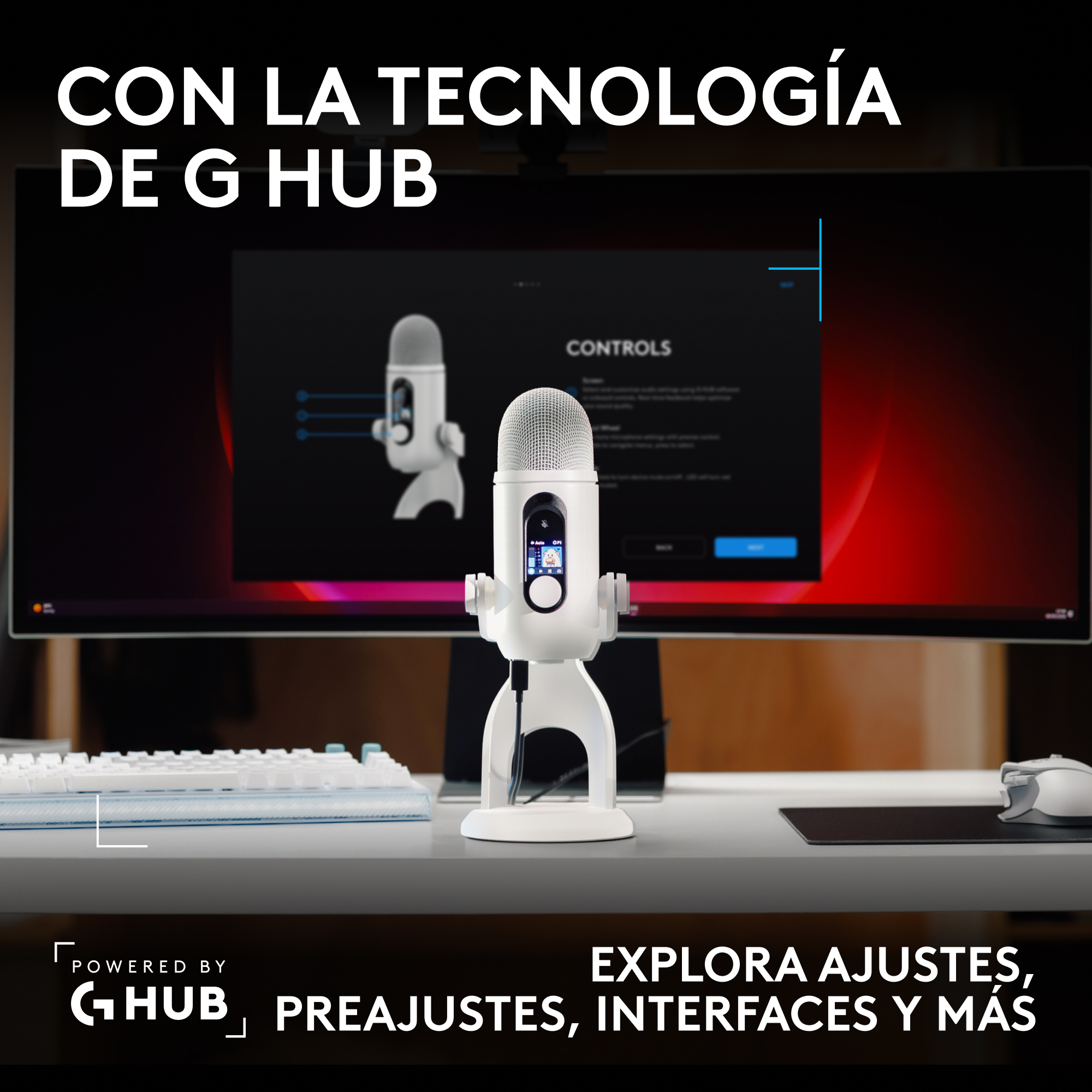Un micrófono blanco con pantalla se encuentra en un escritorio frente a un monitor con controles.