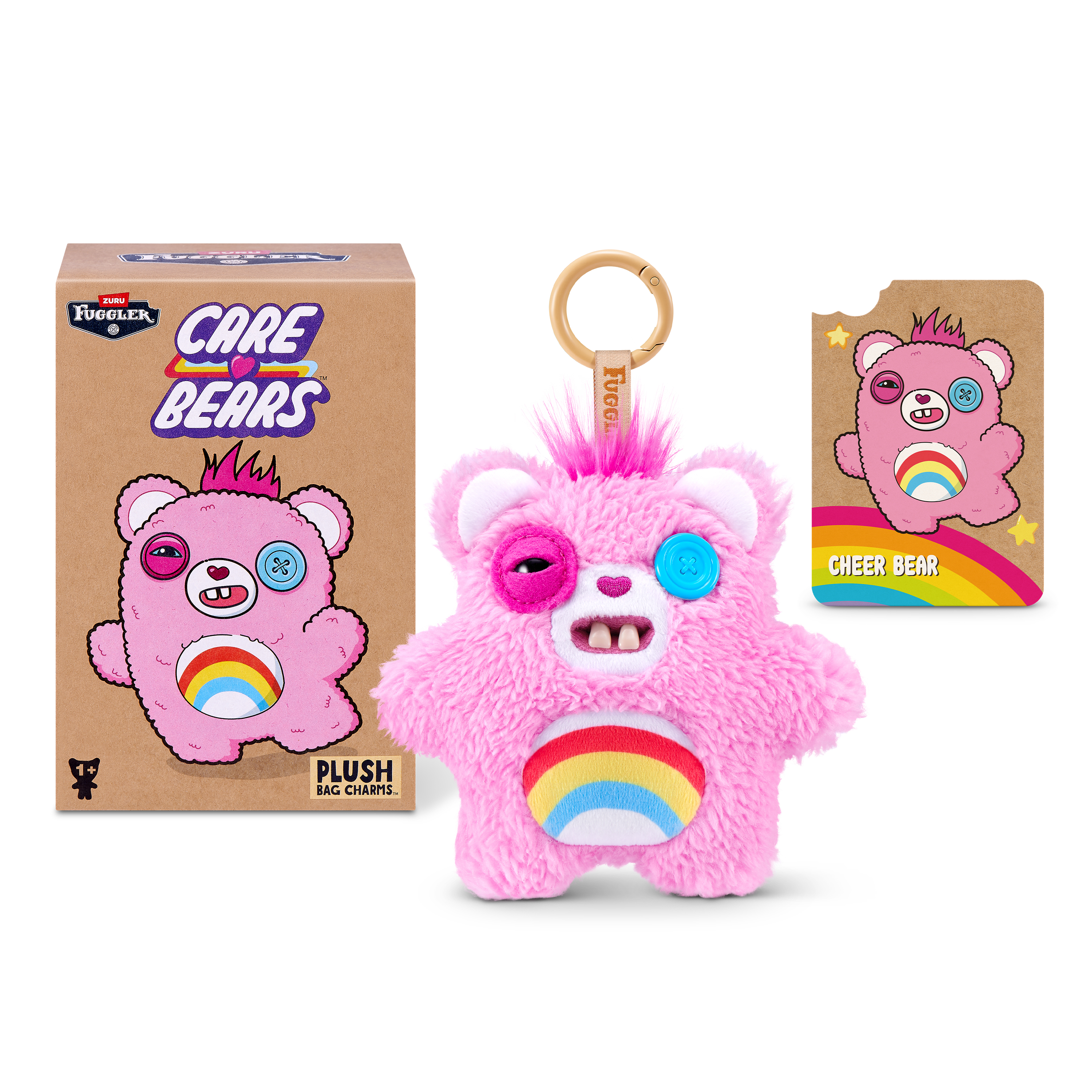 Un peluche de Fuggler Care Bears rosa con arco iris, caja y tarjeta coleccionable sobre un fondo blanco.