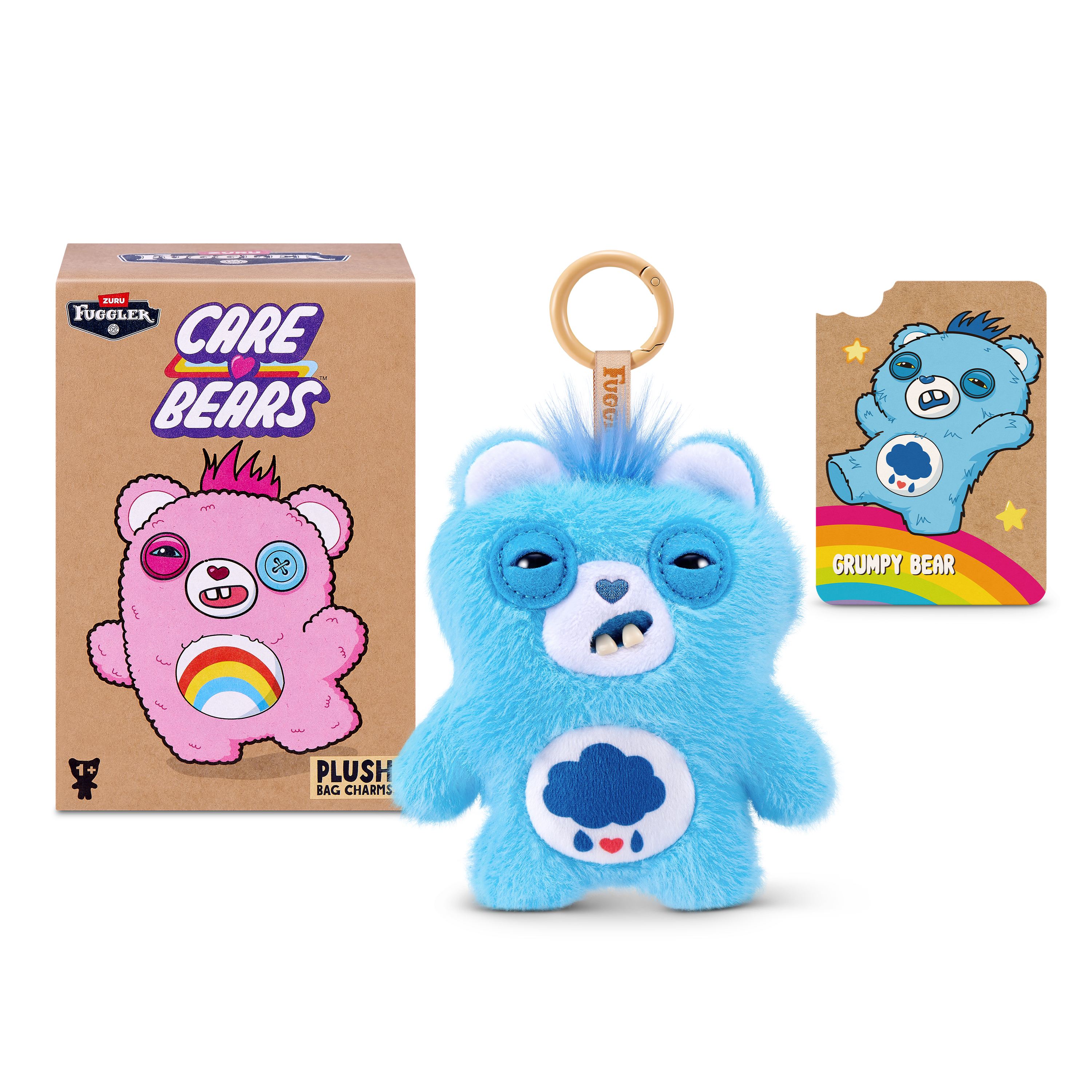 Un peluche azul de Fuggler Care Bears para bolso junto a su caja y una tarjeta de Grumpy Bear.