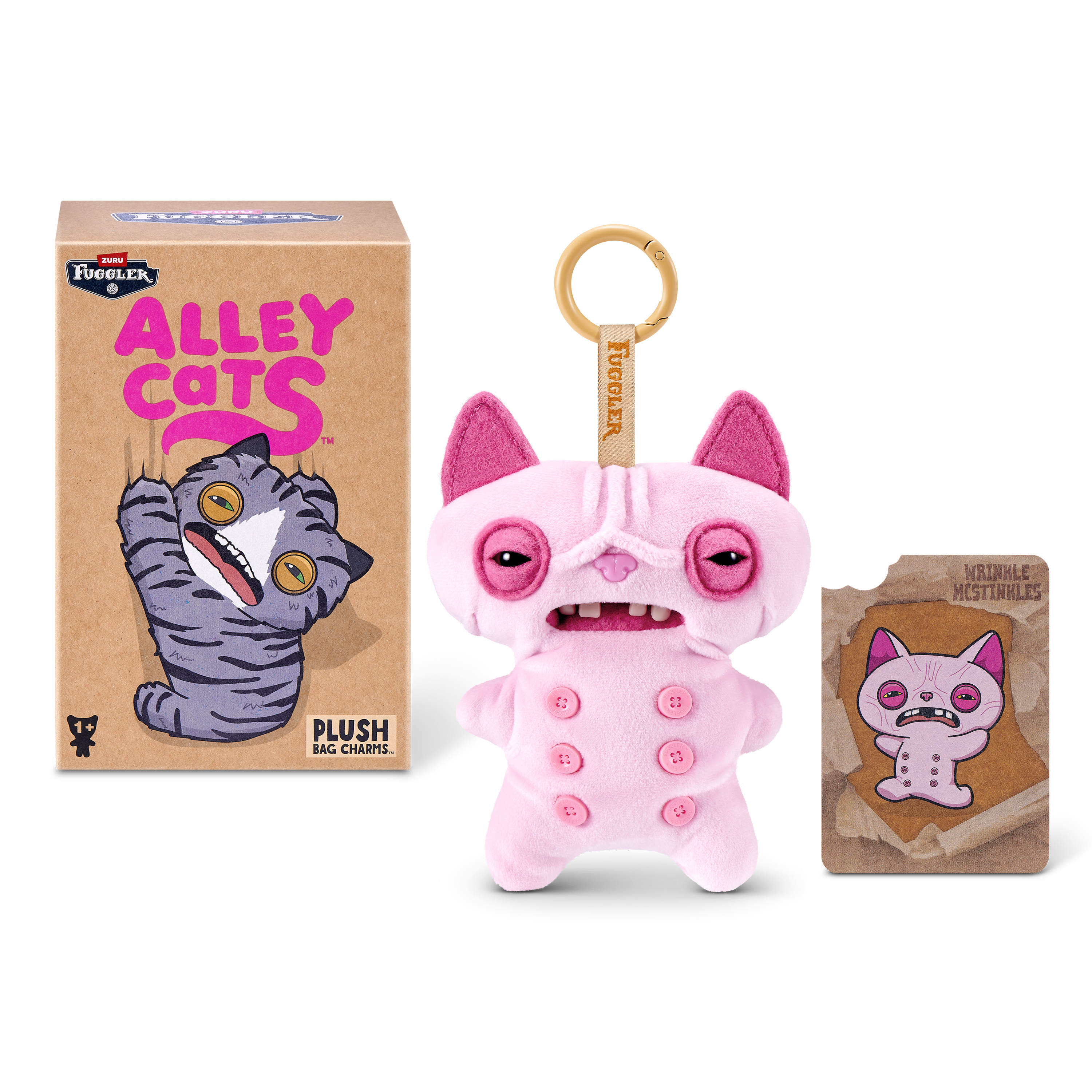 Un llavero de peluche Fuggler rosa con botones, junto con su caja de embalaje y una tarjeta coleccionable.