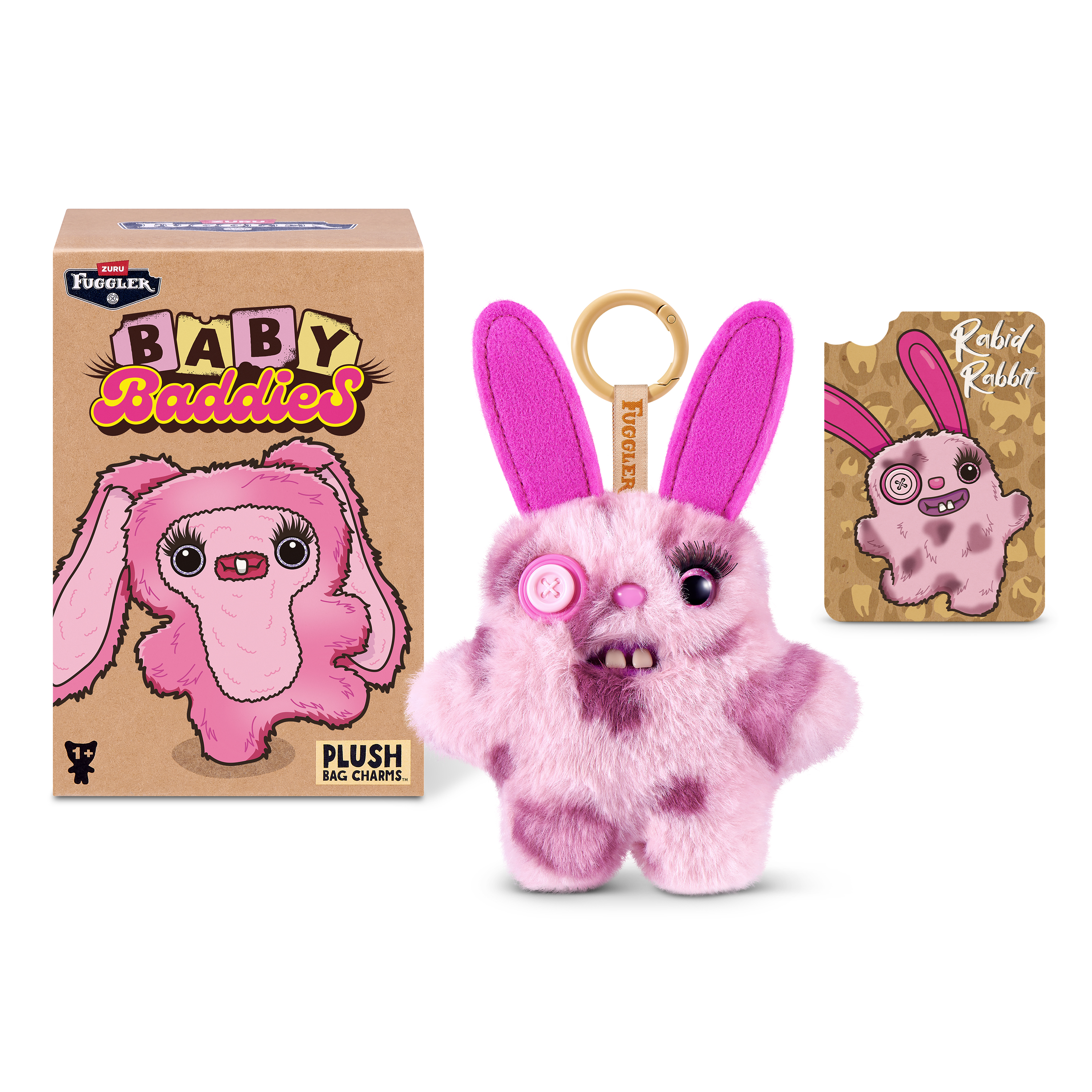 Un peluche de conejo Fuggler rosa y esponjoso con un ojo de botón, caja de embalaje y tarjeta coleccionable.