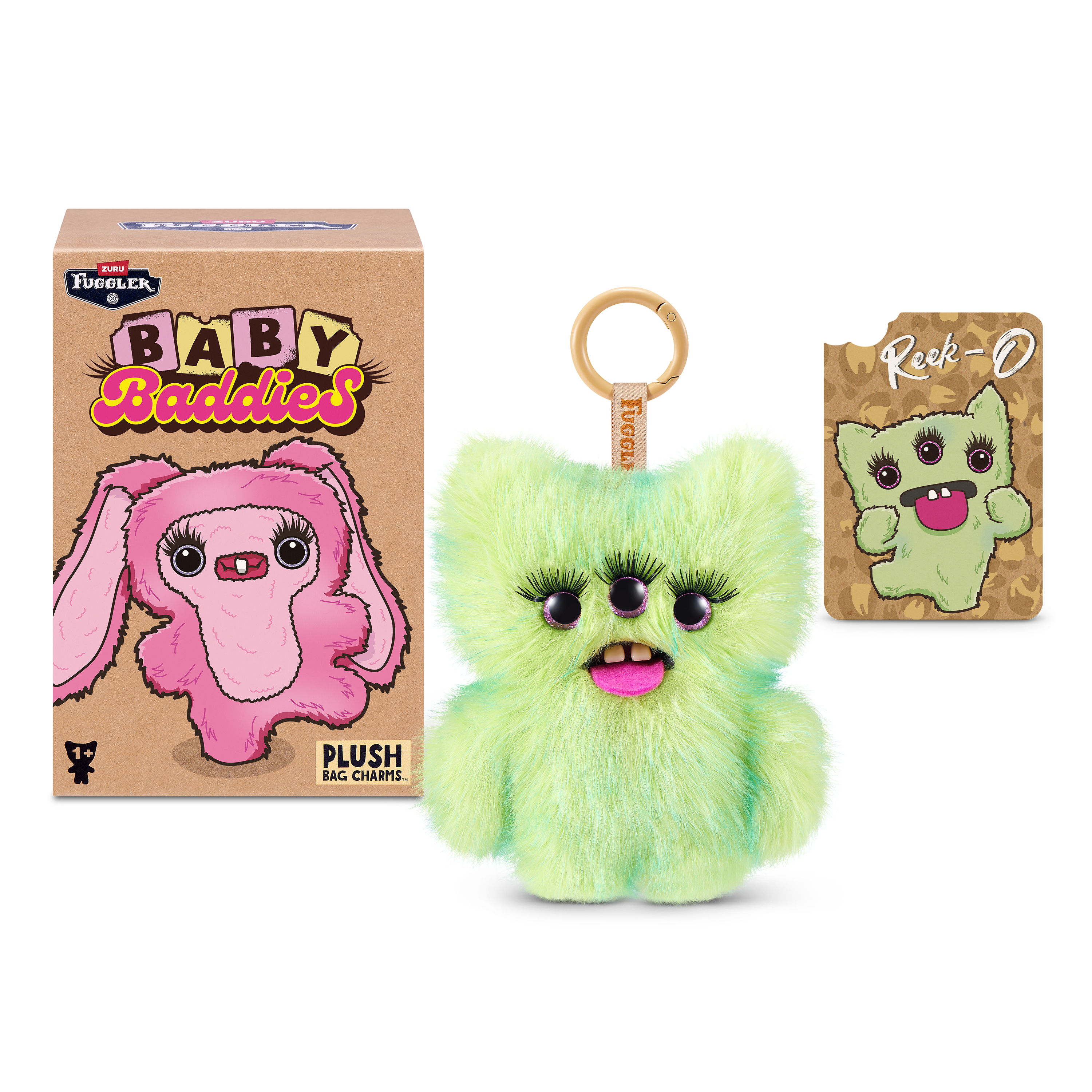 Un llavero de peluche verde con tres ojos y dientes grandes, junto a una caja y una tarjeta.