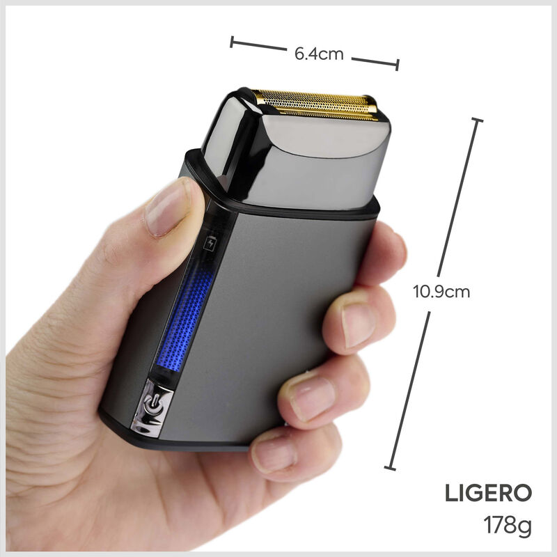 Una mano sostiene una afeitadora eléctrica gris con cabezal dorado y indicador LED azul, mostrando dimensiones y peso.
