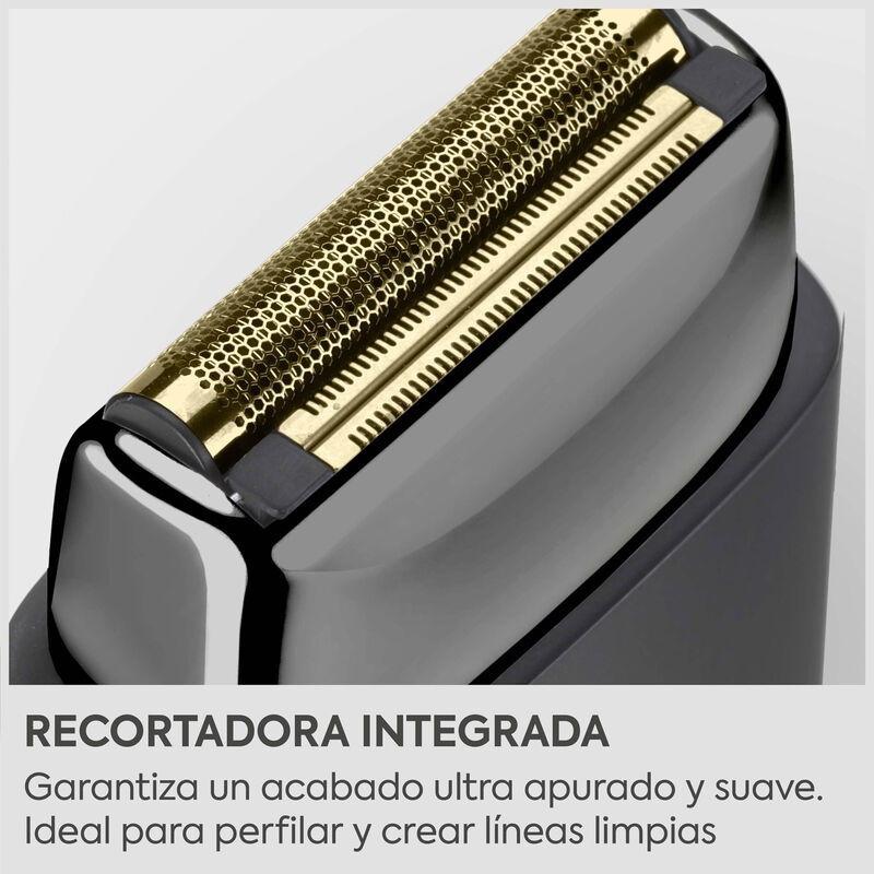 Primer plano de un cabezal de afeitadora con lámina dorada y recortadora sobre cuerpo negro.