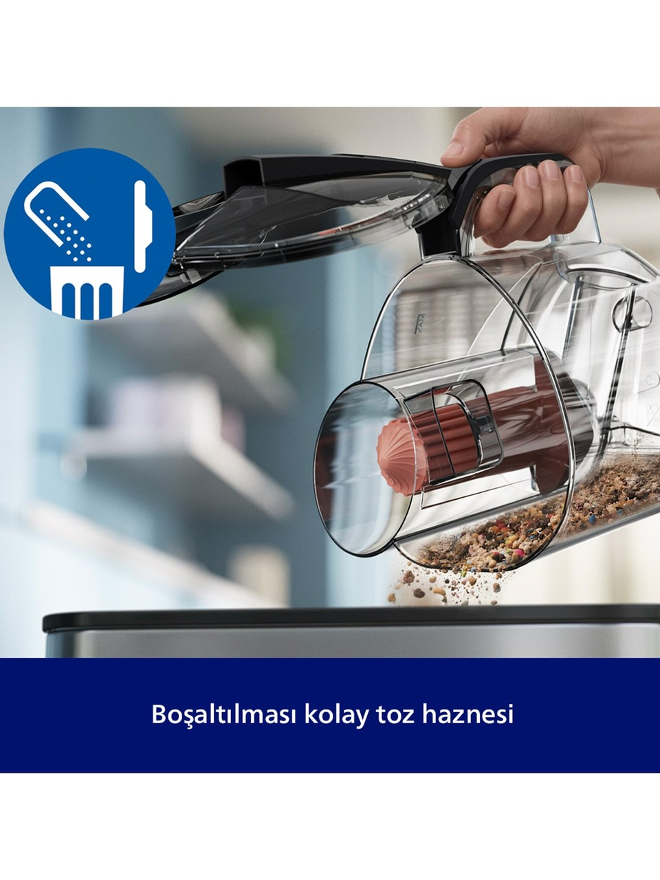 Bir el, elektrikli süpürgenin toz haznesini çöpe boşaltıyor.