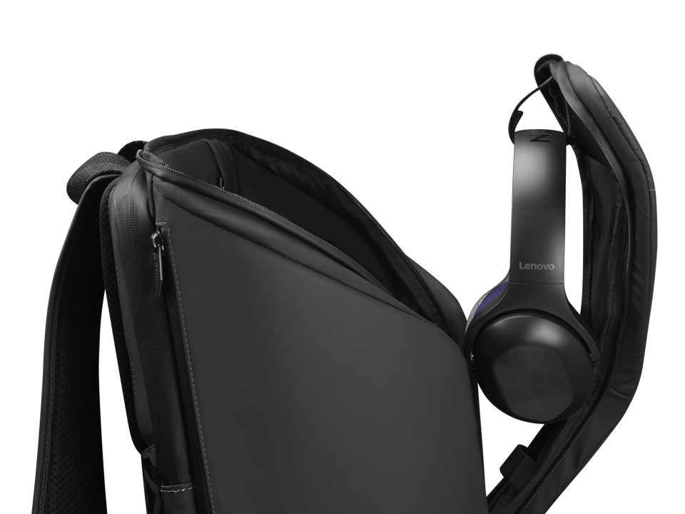 Mochila negra con un compartimento abierto que contiene auriculares Lenovo sobre fondo negro.