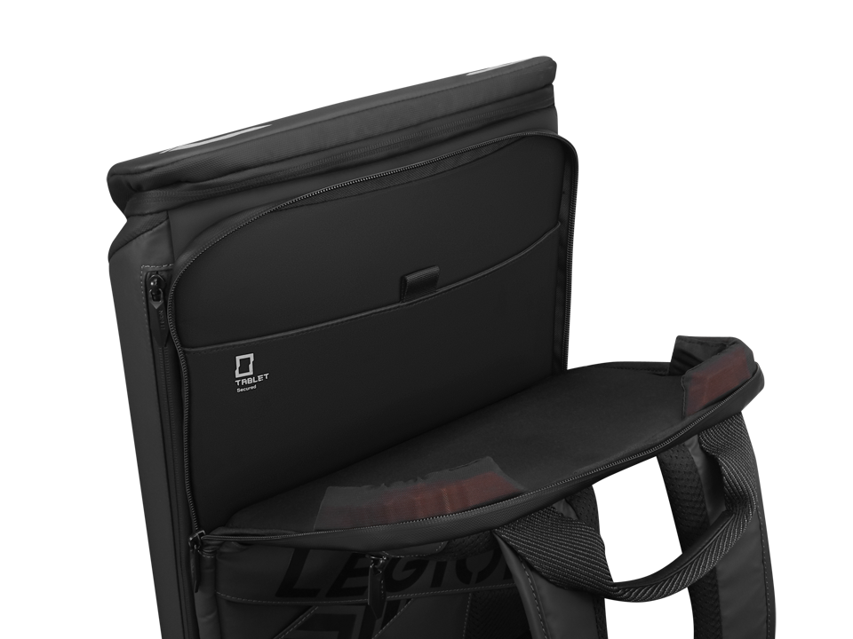 Una mochila negra abierta sobre fondo negro muestra su compartimento principal con bolsillo para tablet.