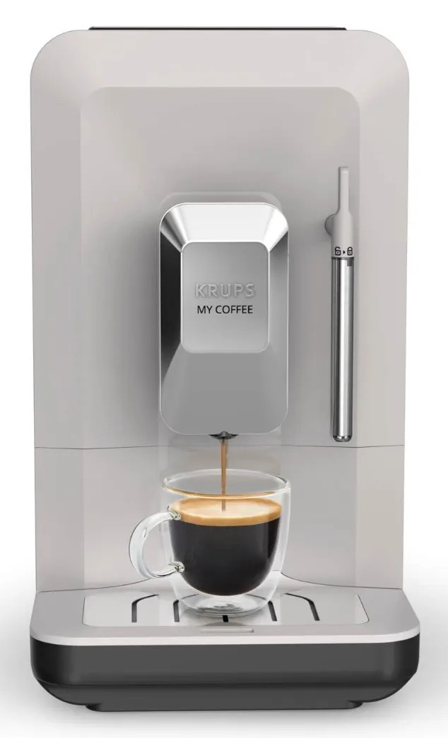 Biały ekspres do kawy Krups My Coffee nalewa espresso do przezroczystej szklanki na srebrnej tacce ociekowej.