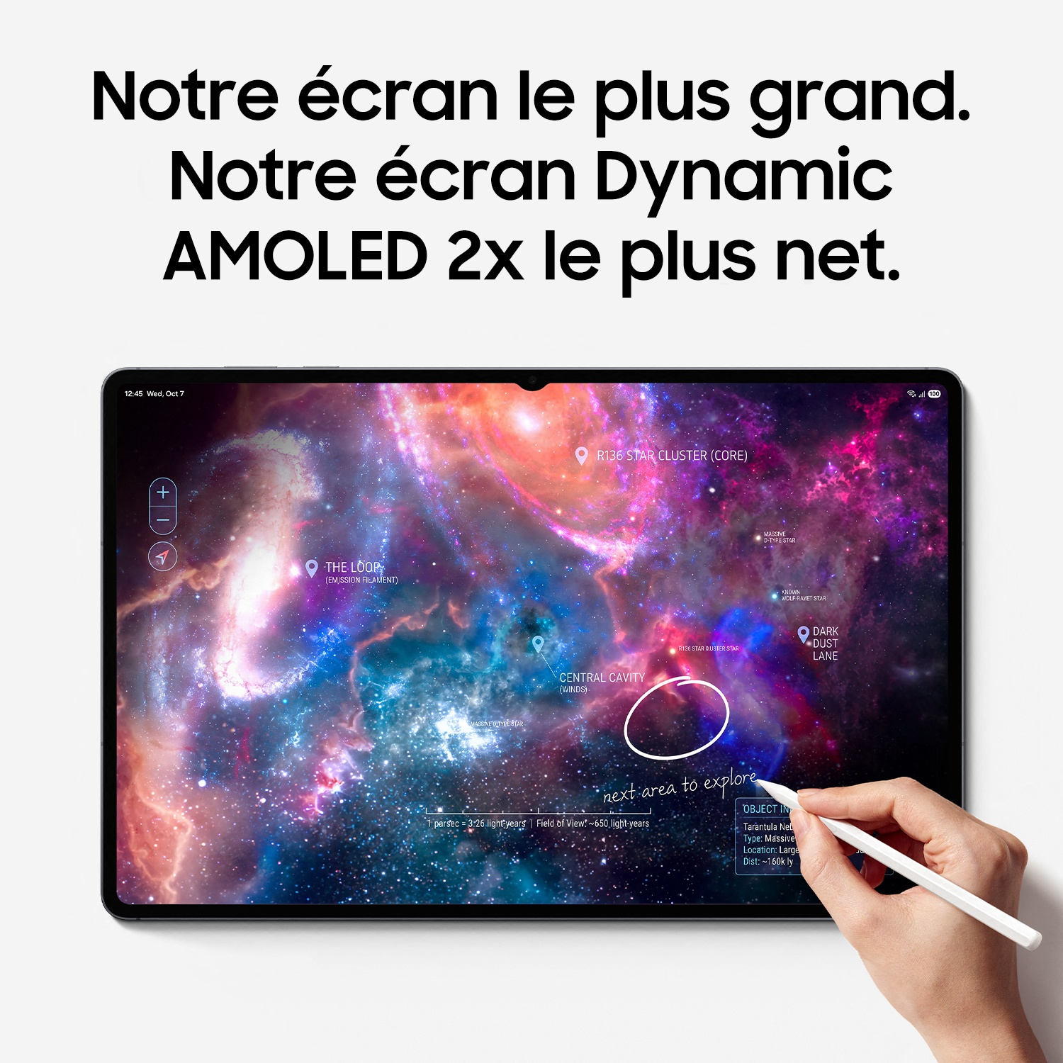 Une tablette affiche une galaxie colorée tandis qu'une main utilise un stylet sur l'écran.