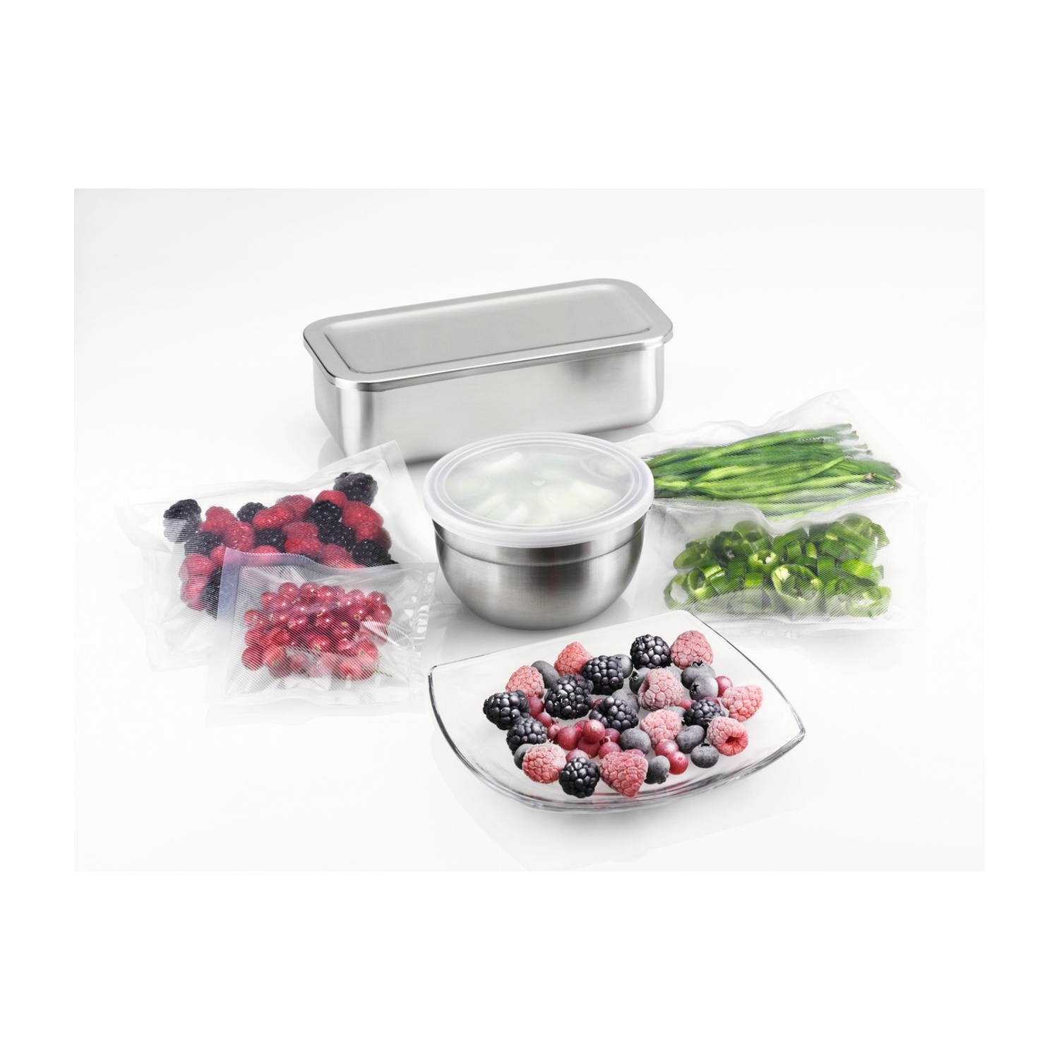 Frutti di bosco e fagiolini in sacchetti sottovuoto, una ciotola e un piatto su sfondo bianco.