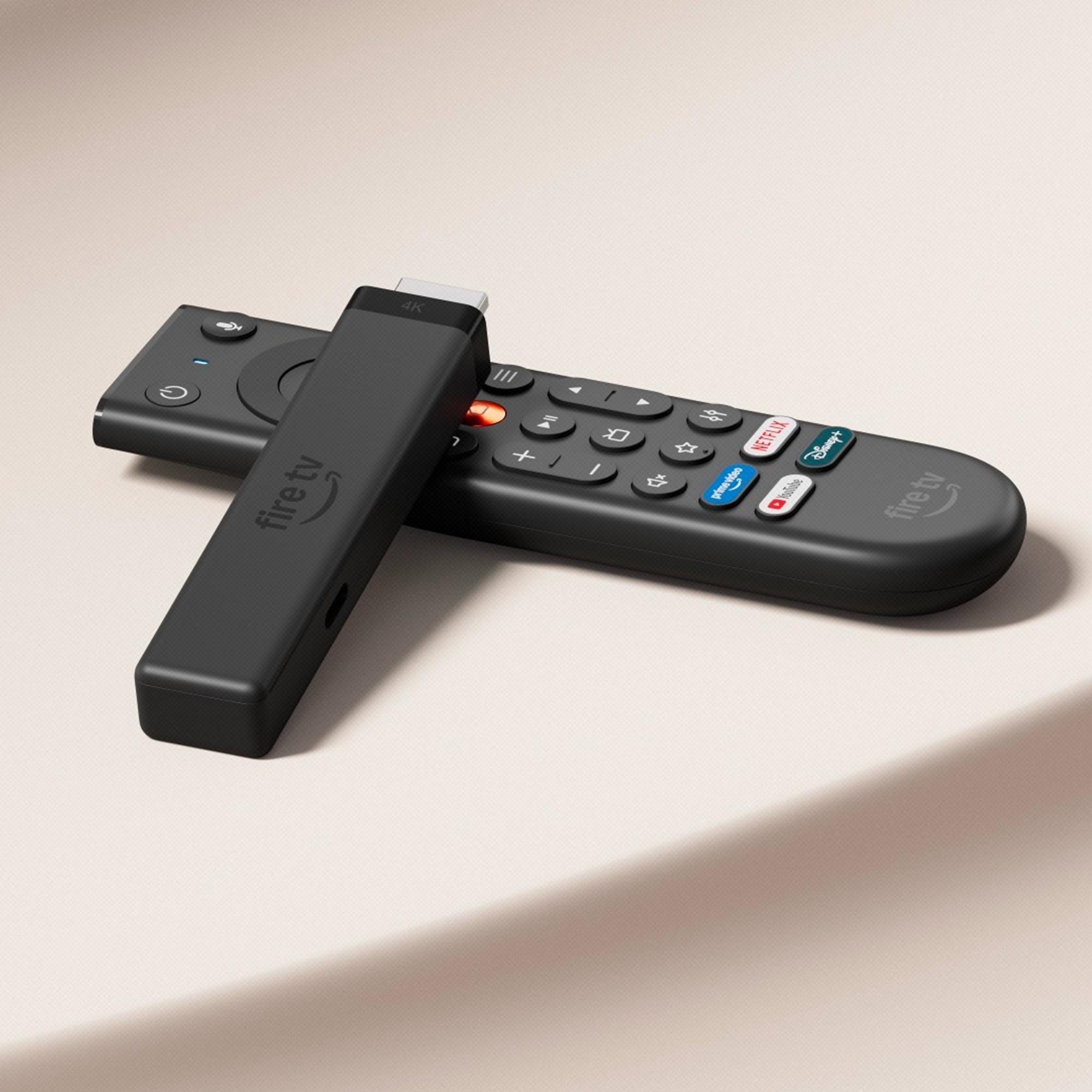 Ein schwarzer Amazon Fire TV Stick 4K liegt diagonal auf seiner Fernbedienung vor einem hellen Hintergrund.