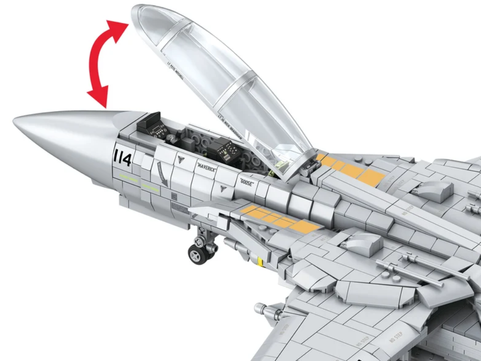Ein detailliertes graues Spielzeugflugzeug mit offenem Cockpit und einem roten Pfeil, der die Bewegung zeigt.