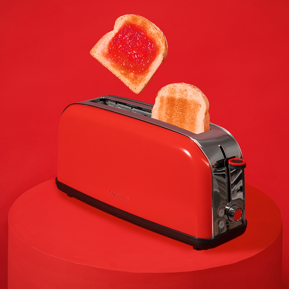 Una tostadora roja en un podio rojo, con una rebanada de pan tostado con mermelada flotando arriba.