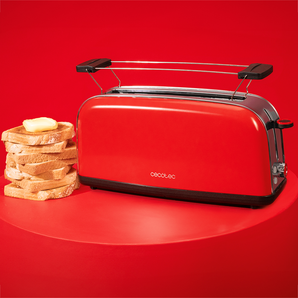 Una tostadora roja sobre una mesa roja junto a una pila de pan tostado con mantequilla.