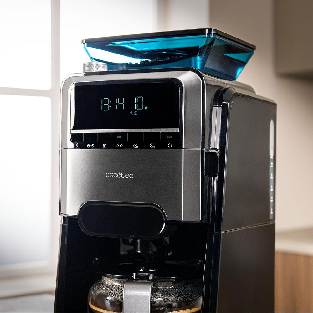 Cafetera moderna con pantalla digital y tolva de granos azul en la encimera de la cocina.