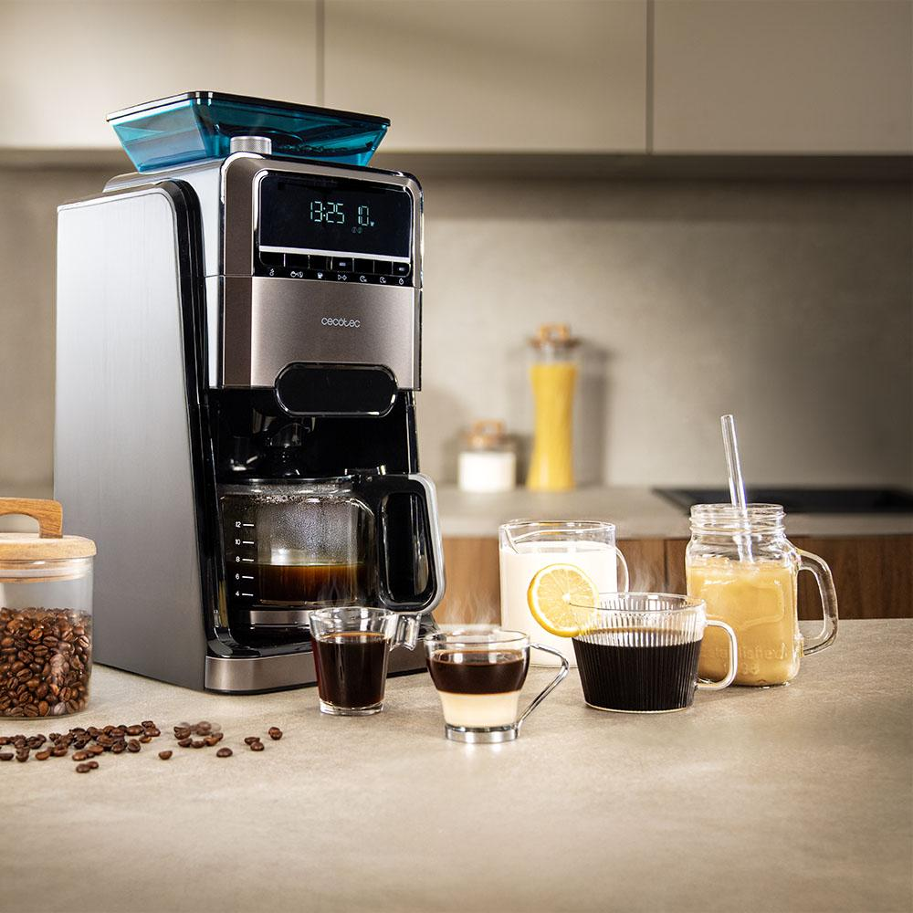Una cafetera moderna en un mostrador con tazas de café, leche y granos de café.