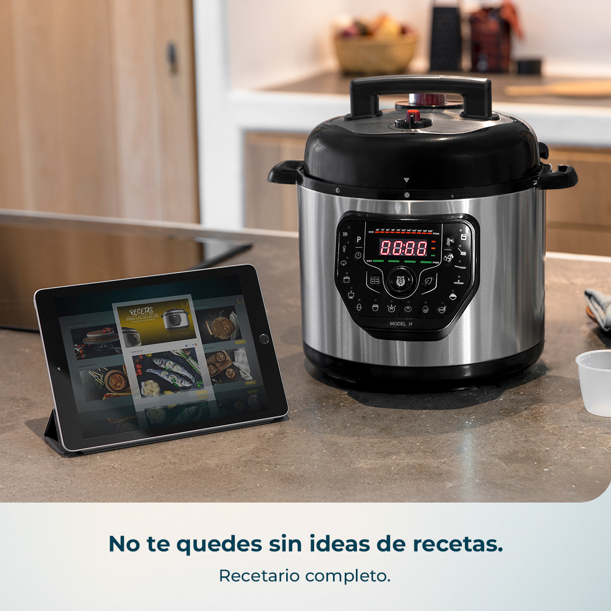 Olla multicocina y tablet con recetas en encimera de cocina.