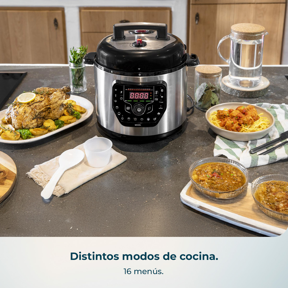 Olla a presión eléctrica de acero en una encimera de cocina, rodeada de pollo asado, pasta y cuencos con comida.