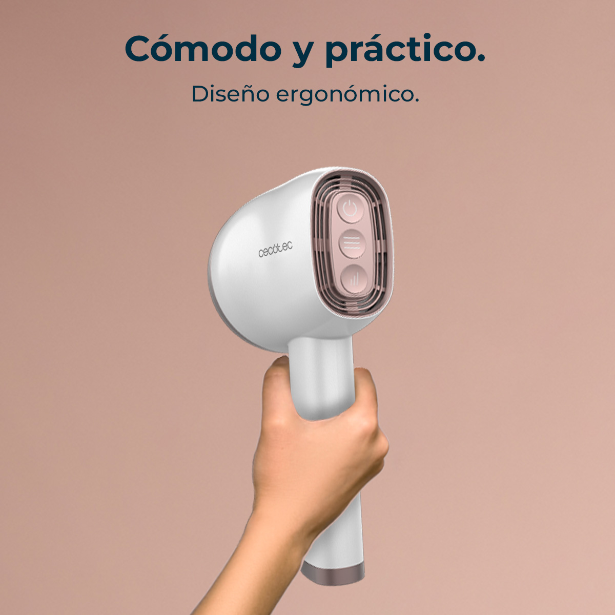 Una mano sostiene un cepillo de vapor Cecotec blanco y ergonómico sobre un fondo beige.