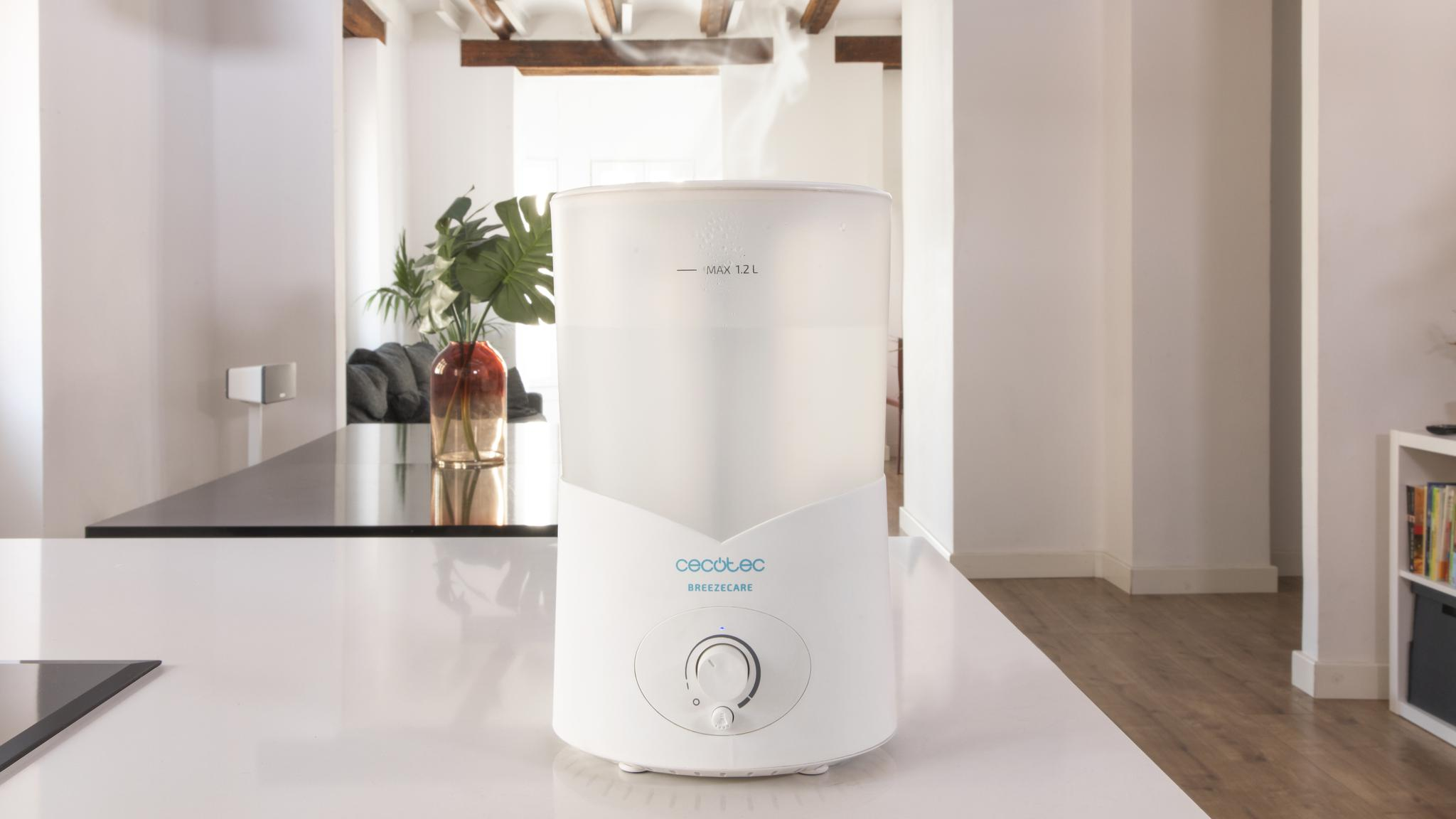 Un humidificador blanco Cecotec BREEZECARE sobre una encimera blanca en una habitación moderna.