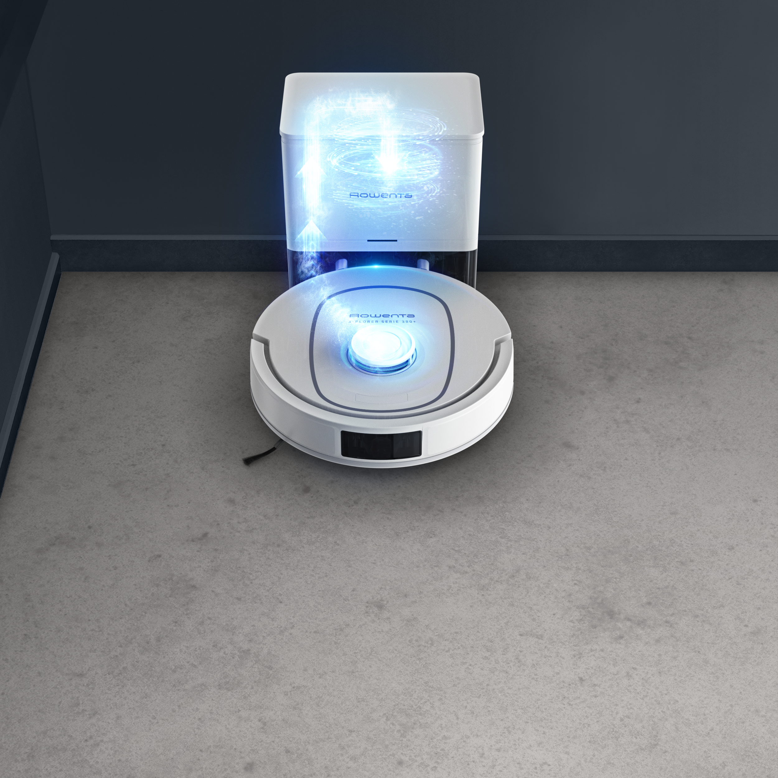 Egy fehér robotporszívó dokkol egy állomáson egy szürke padlón, kék grafikával mutatva a légáramlást.
