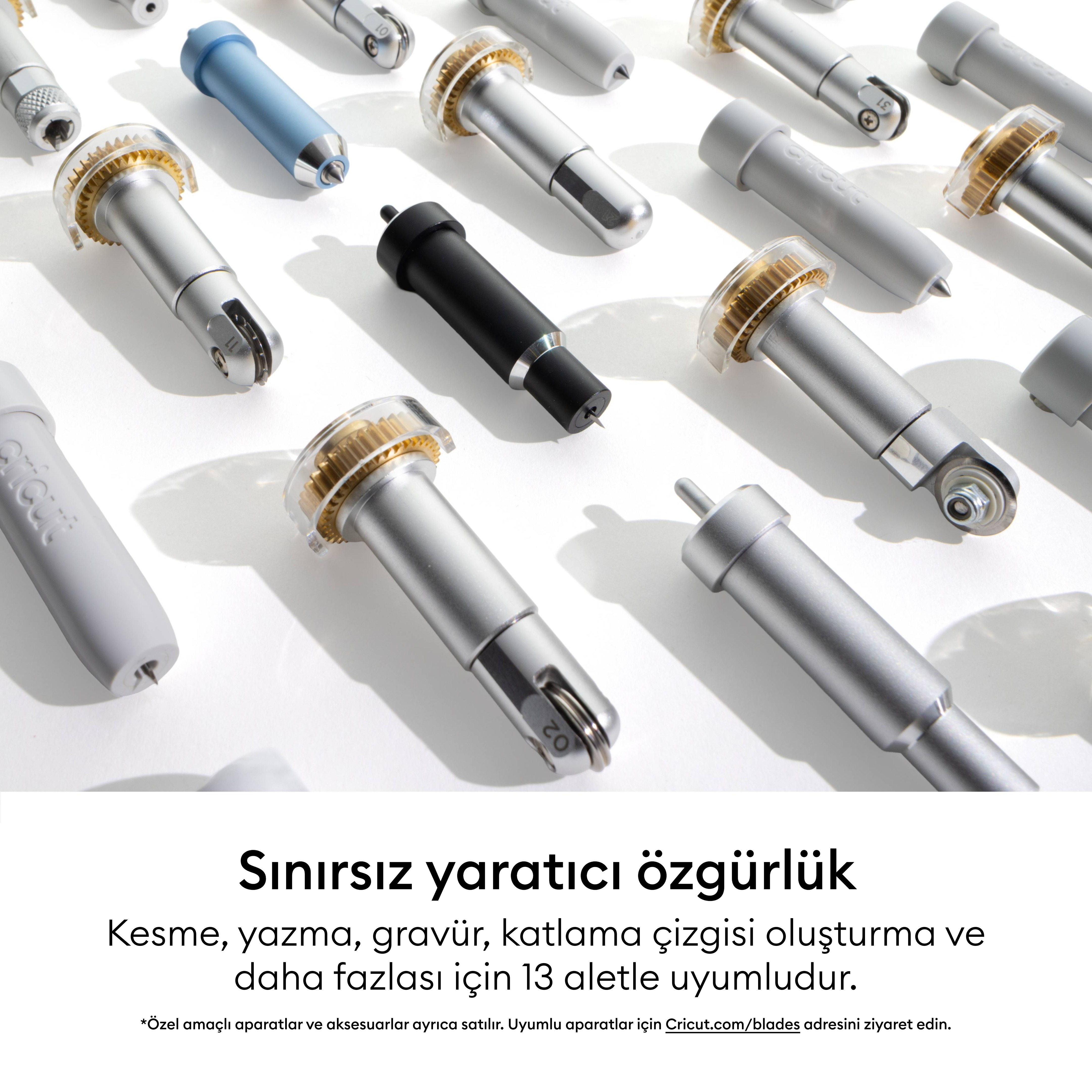 Beyaz bir arka plan üzerinde düzenlenmiş çeşitli gümüş ve renkli Cricut kesici aletler ve bıçaklar.