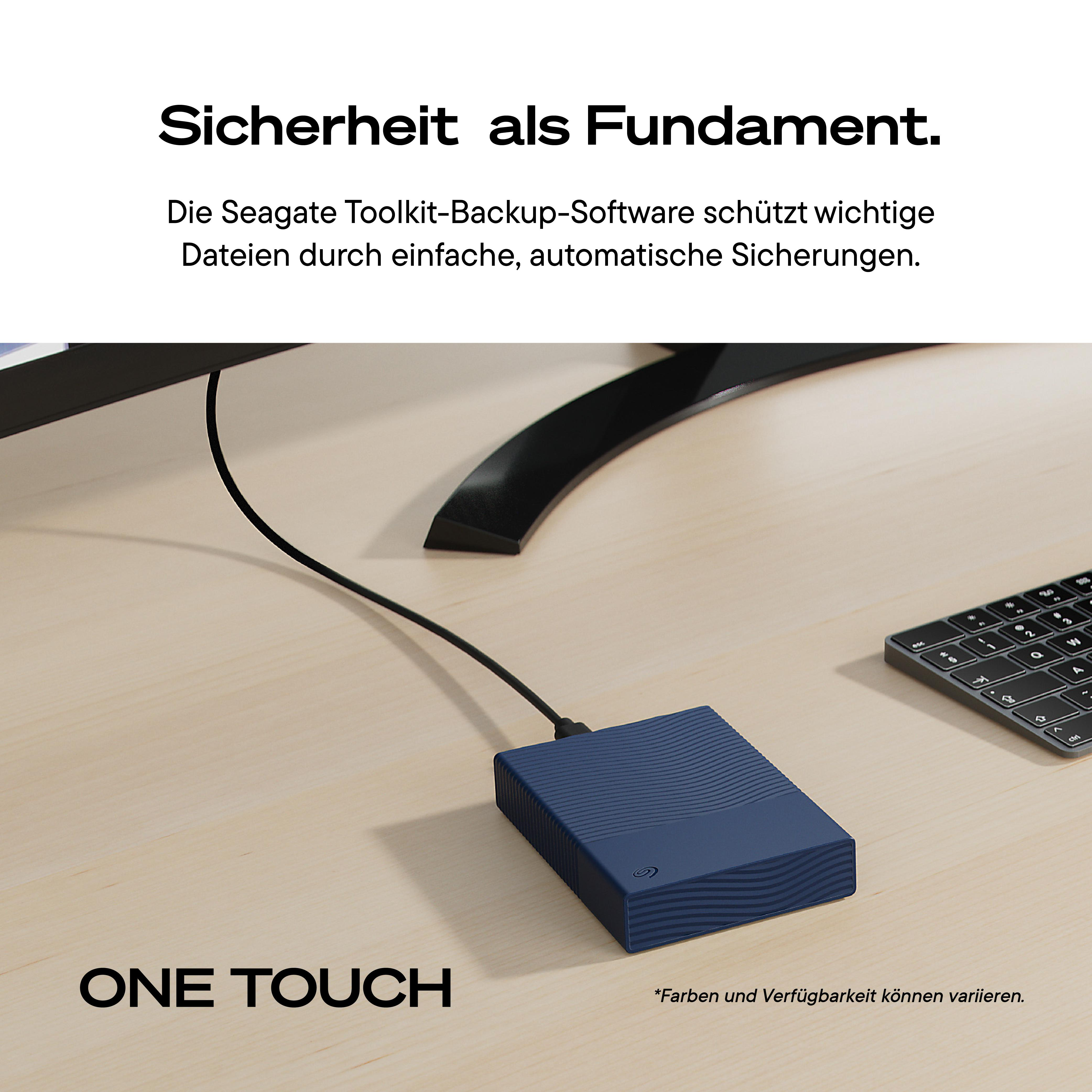 Blaue Seagate One Touch Festplatte auf einem Schreibtisch mit Monitor und Tastatur, verbunden mit Kabel.