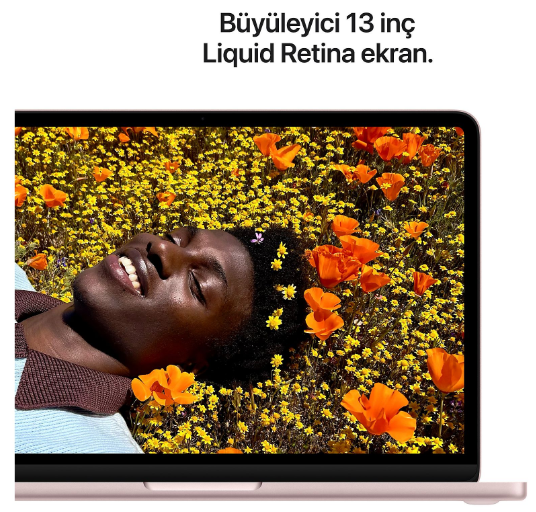 Ekranında sarı ve turuncu çiçeklerle dolu tarlada yatan bir kadın olan MacBook.