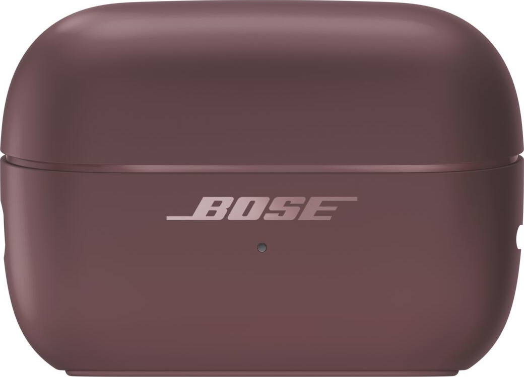 Ein geschlossenes, pflaumenfarbenes Bose-Ladecase für kabellose Ohrhörer mit silbernem Logo und LED-Anzeige.