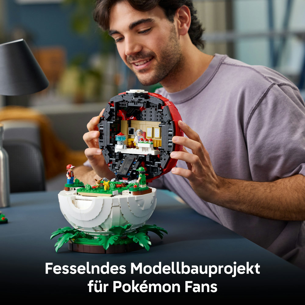 Ein Mann baut ein geöffnetes Pokéball-Modell aus Lego-Steinen.