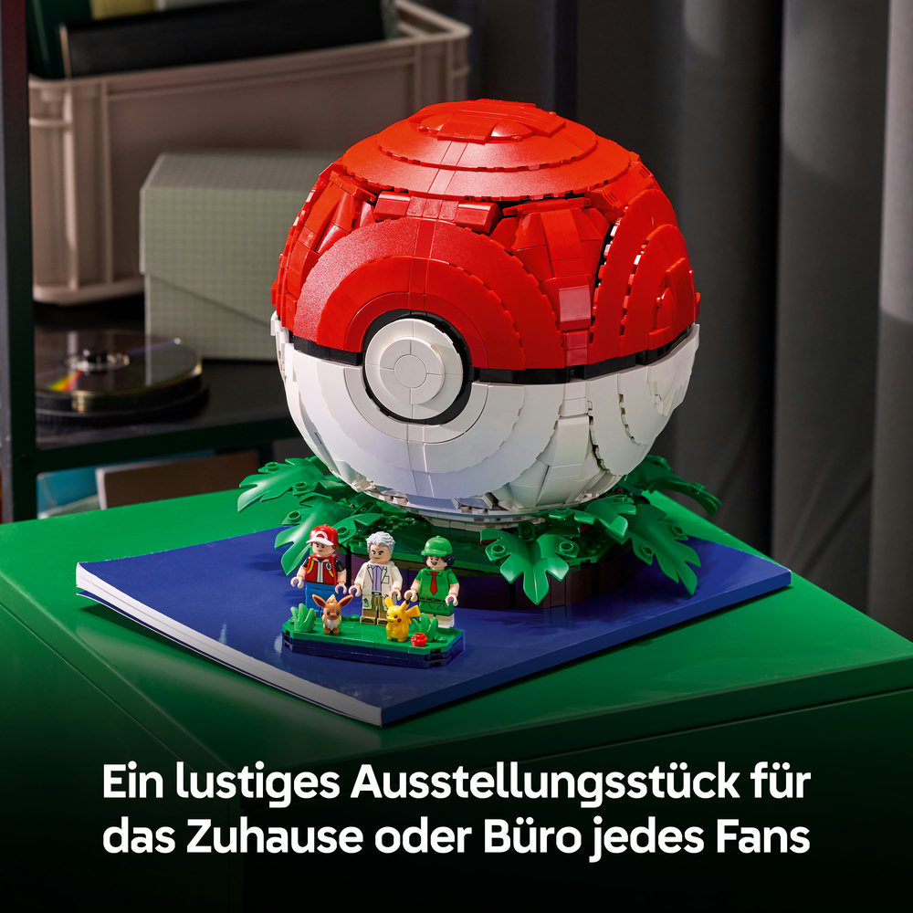 Ein Lego-Modell eines Pokéballs mit kleinen Figuren auf einem grünen Tisch.