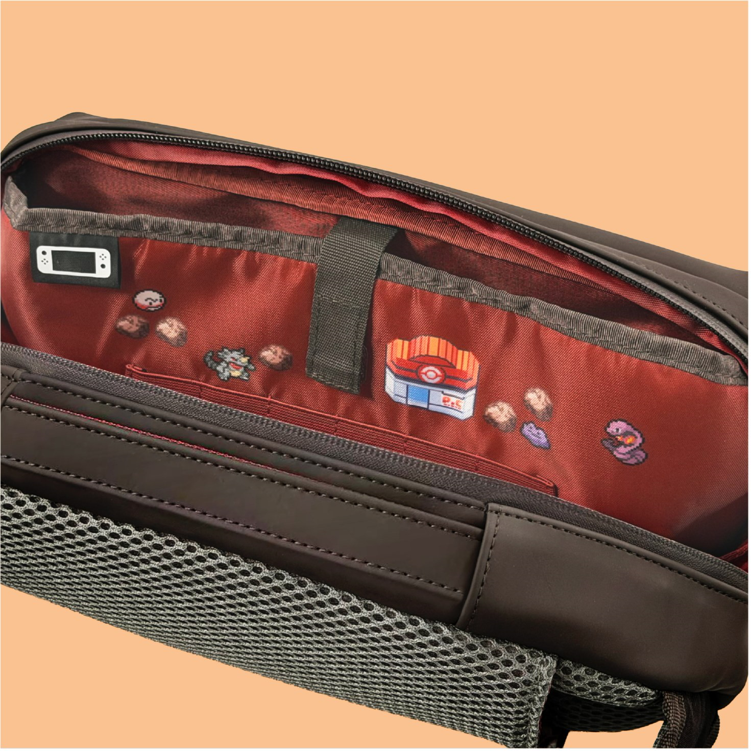 Una borsa marrone aperta mostra un interno rosso decorato con elementi Pokémon pixelati su sfondo beige.