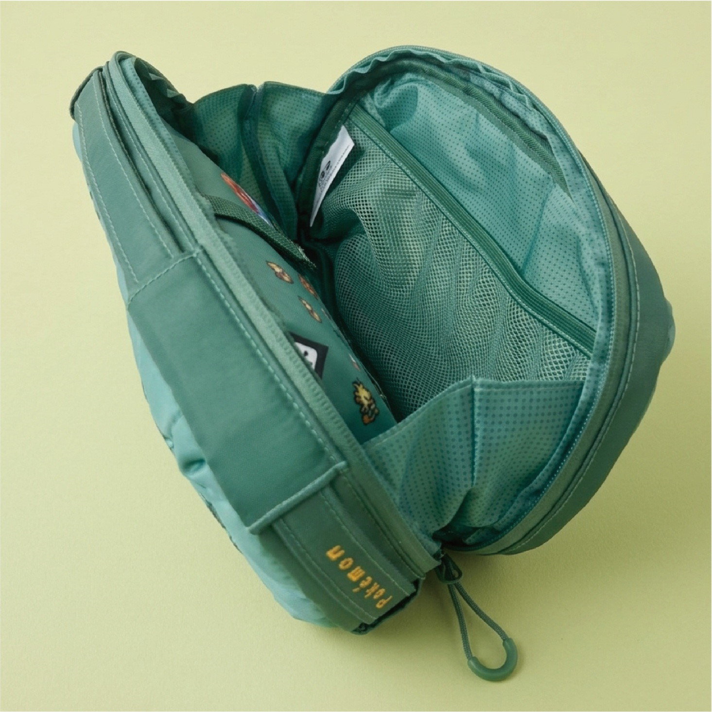 Una borsa verde aperta con cerniera e tasche interne in rete.