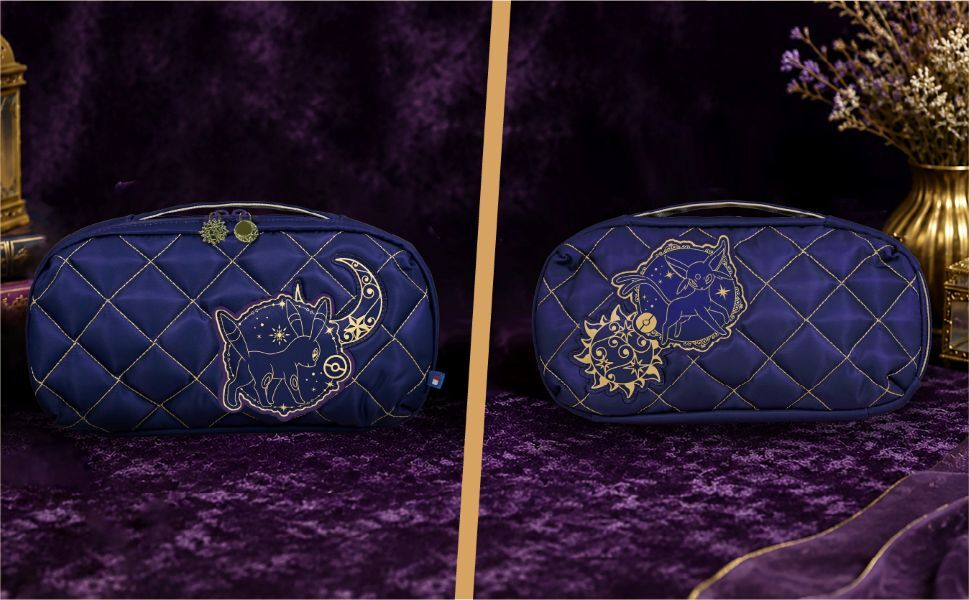 Due borse cosmetiche trapuntate blu navy con ricami Pokémon dorati su sfondo viola.