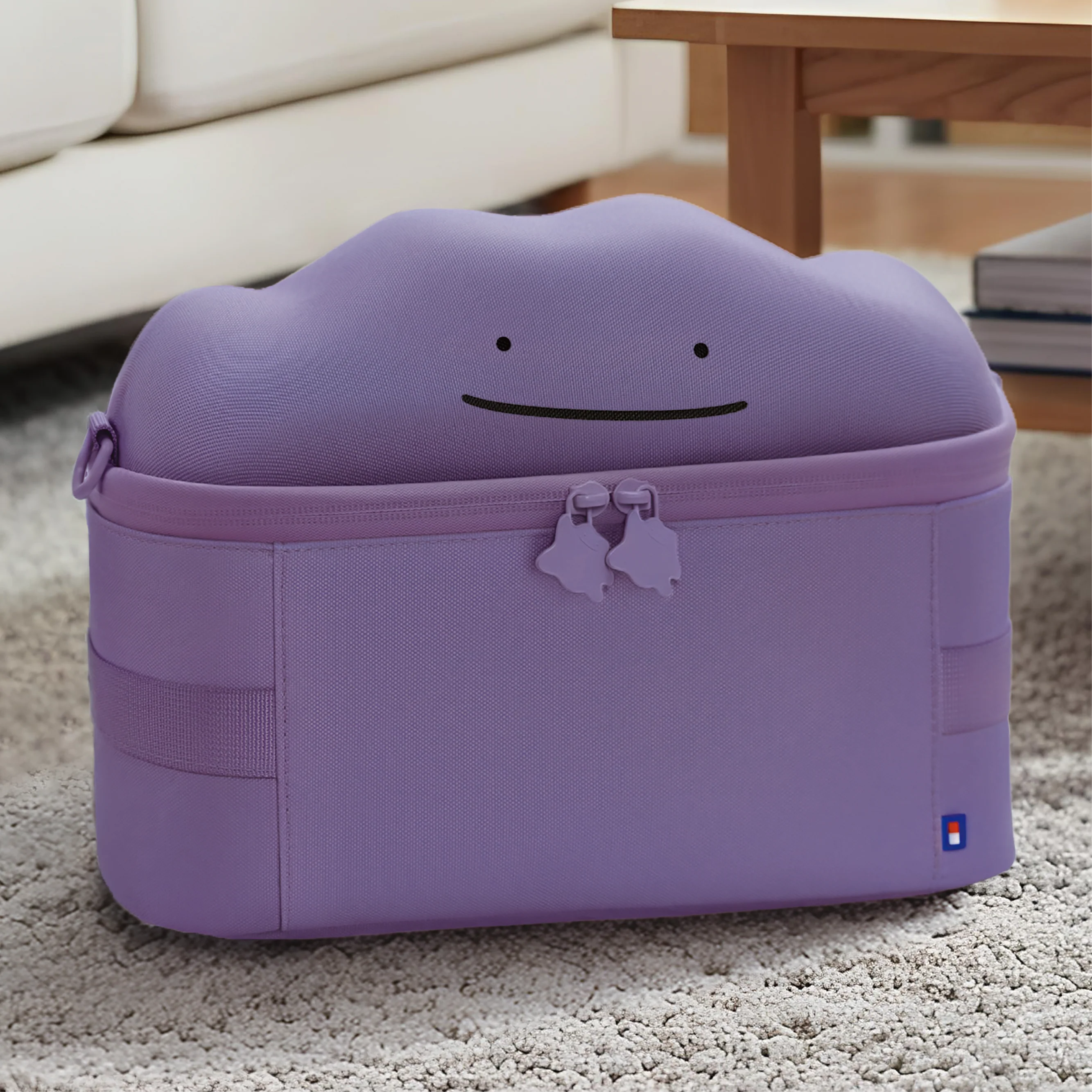 Borsa viola sul tappeto con una faccia di Ditto sul coperchio.