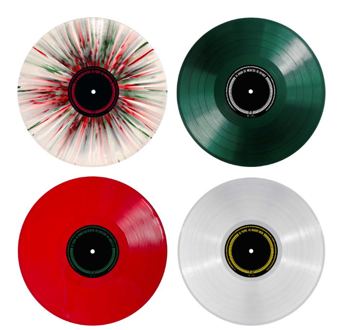Vier verschiedene Vinyl-Schallplatten: eine spritzerverzierte, eine grüne, eine rote und eine weiße.