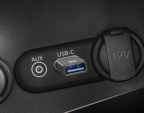 Un panel de coche con un puerto AUX, un puerto USB-C y una toma de corriente de 12V.