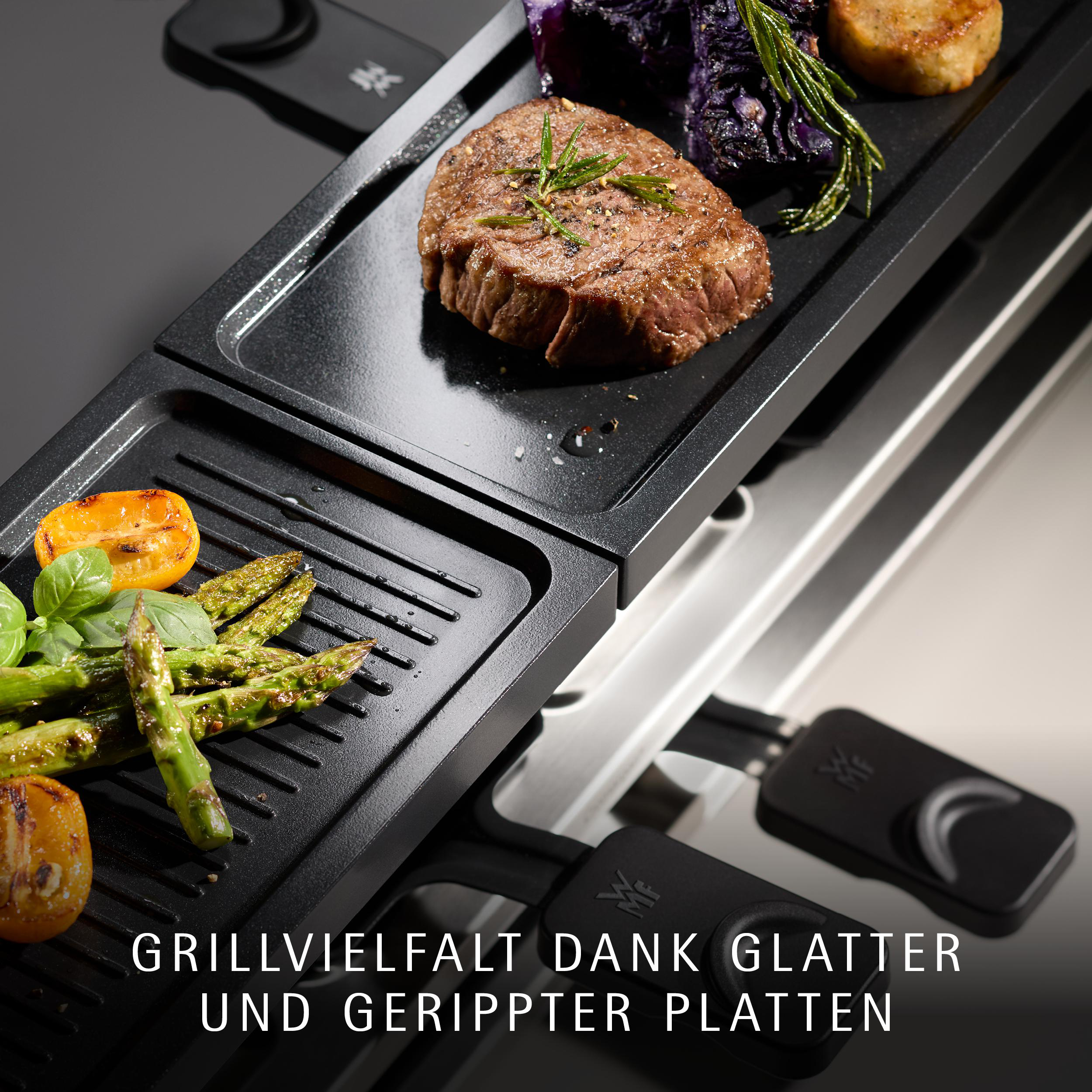 Ein schwarzer Elektrogrill mit glatten und gerippten Platten gart ein Steak, Spargel und Rotkohl.