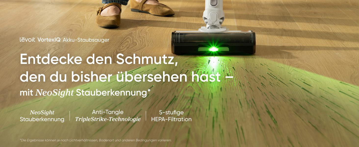 Ein Akkustaubsauger beleuchtet mit grünem Licht Schmutz auf einem Holzboden.