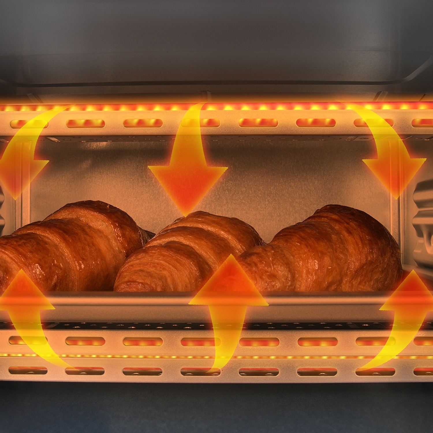 Tre croissant cuociono in un forno con elementi riscaldanti e frecce arancioni.