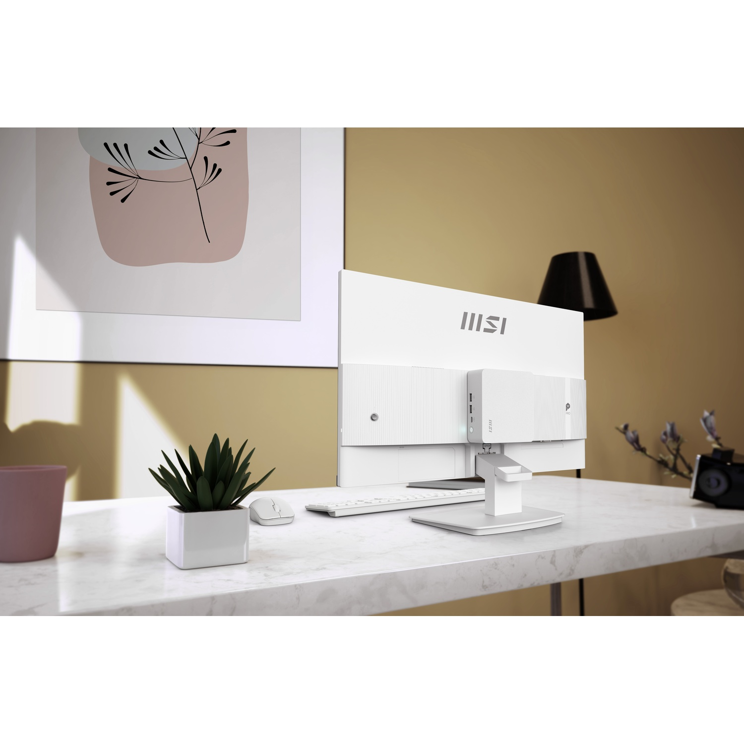 Un PC all-in-one MSI bianco su una scrivania di marmo con pianta, tastiera e opera d'arte moderna.