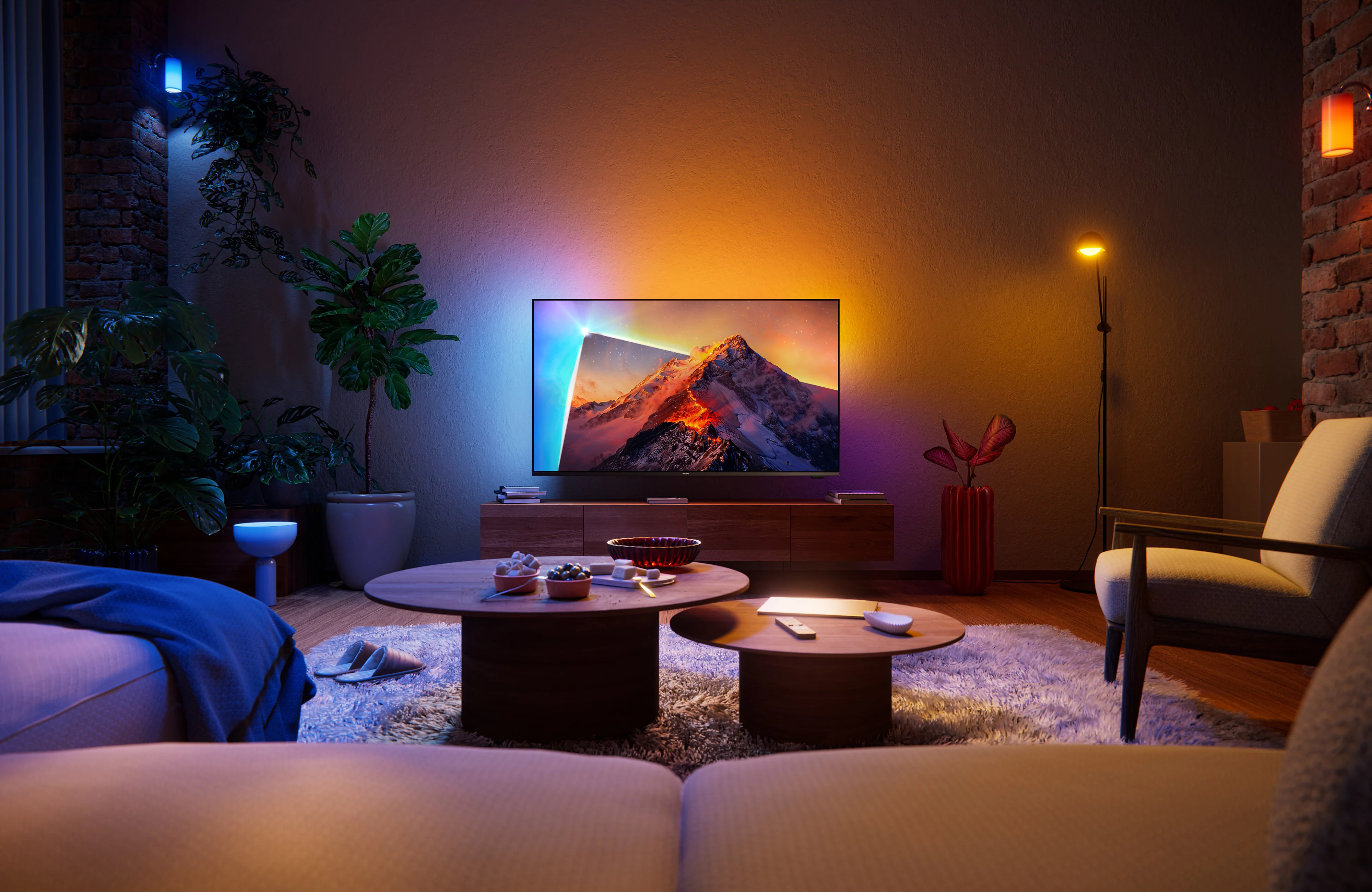 Salon avec une télévision affichant une montagne, entouré de plantes, de meubles en bois et d'un éclairage chaleureux.