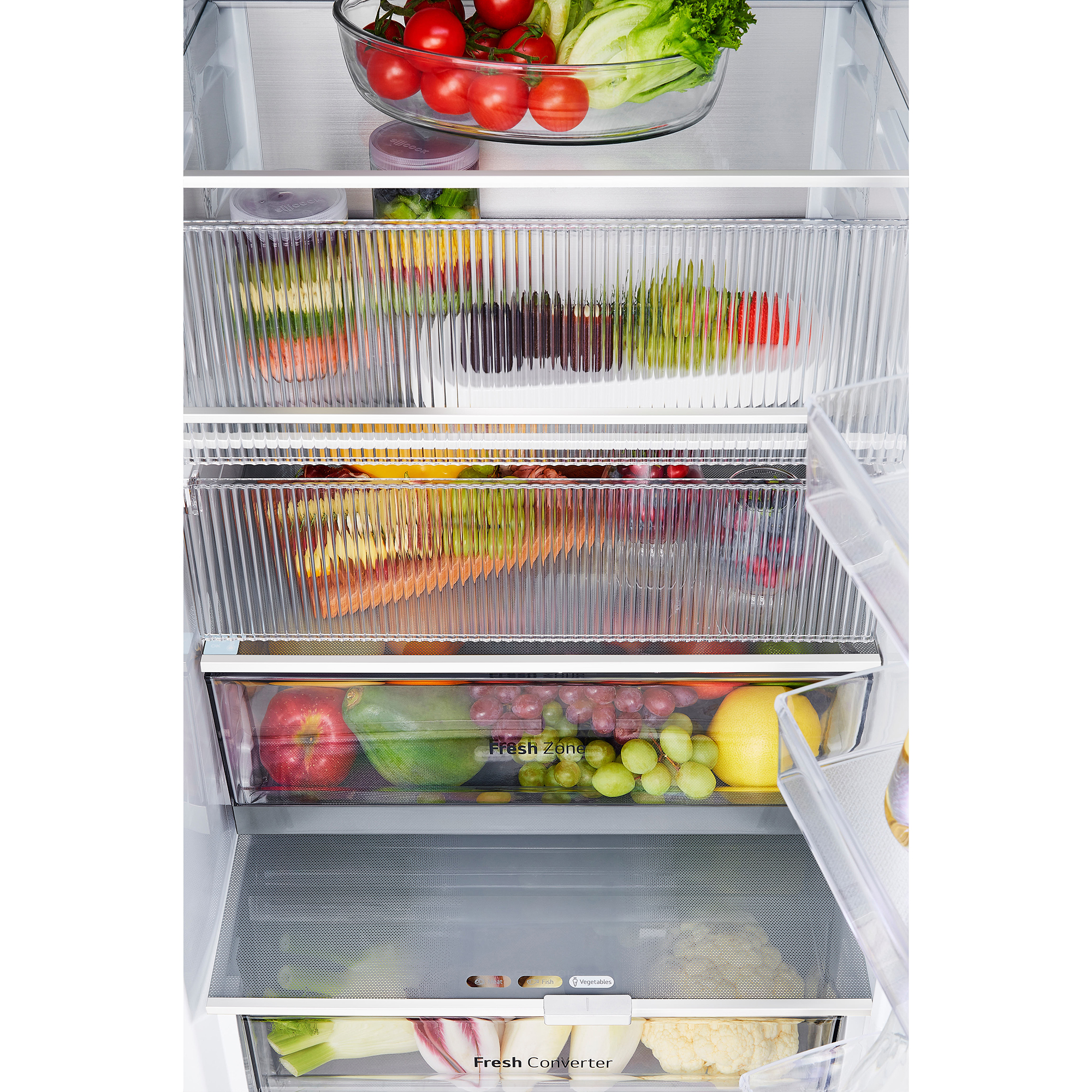 Frigorífico abierto lleno de diversos alimentos frescos, verduras y frutas en estantes y compartimentos transparentes.