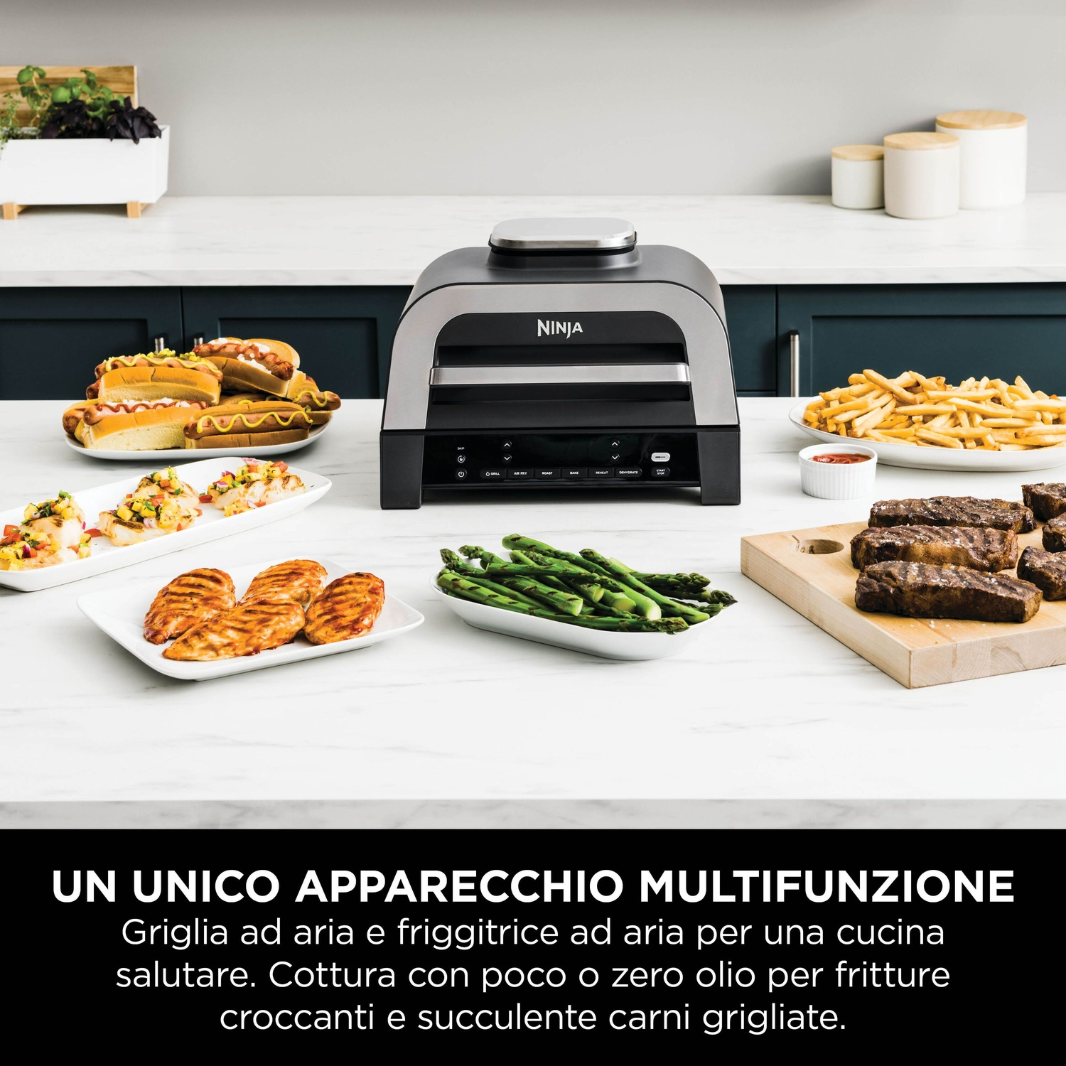 Dispositivo multifunzione Ninja su piano cucina con vari cibi preparati come carne, pesce, hot dog e patatine.