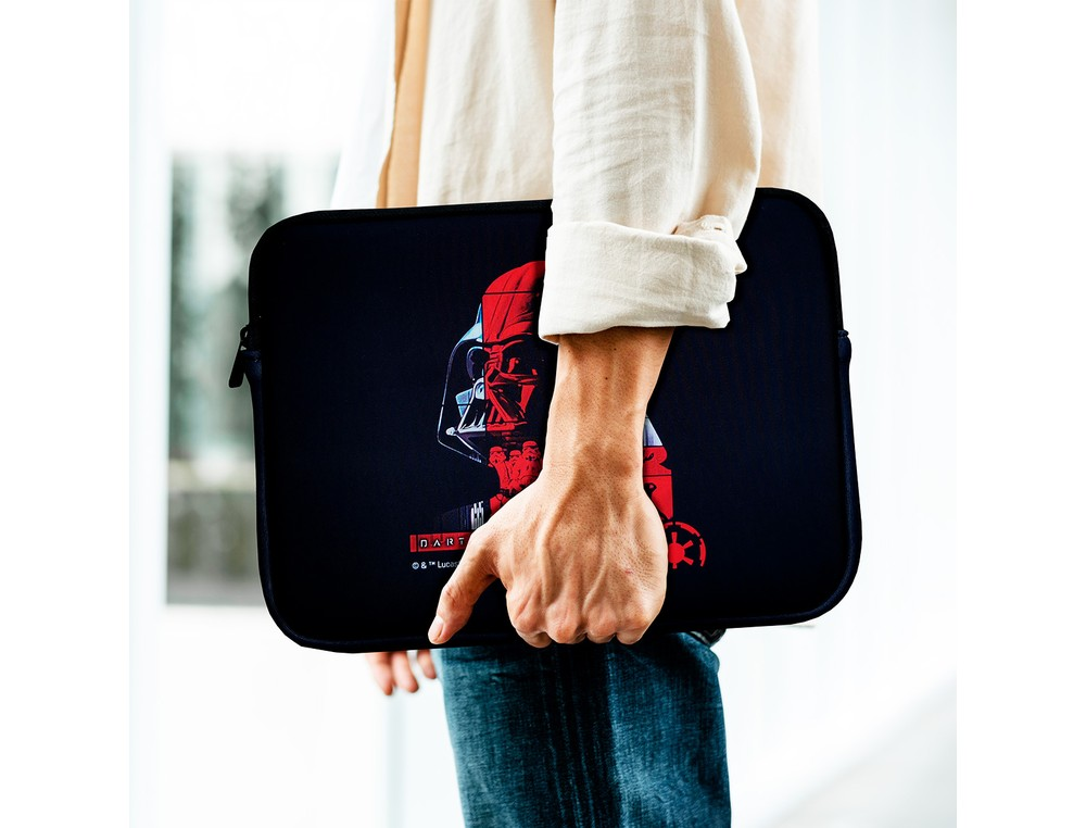 Persona con camisa blanca y jeans lleva una funda de portátil negra con diseño de Darth Vader rojo.